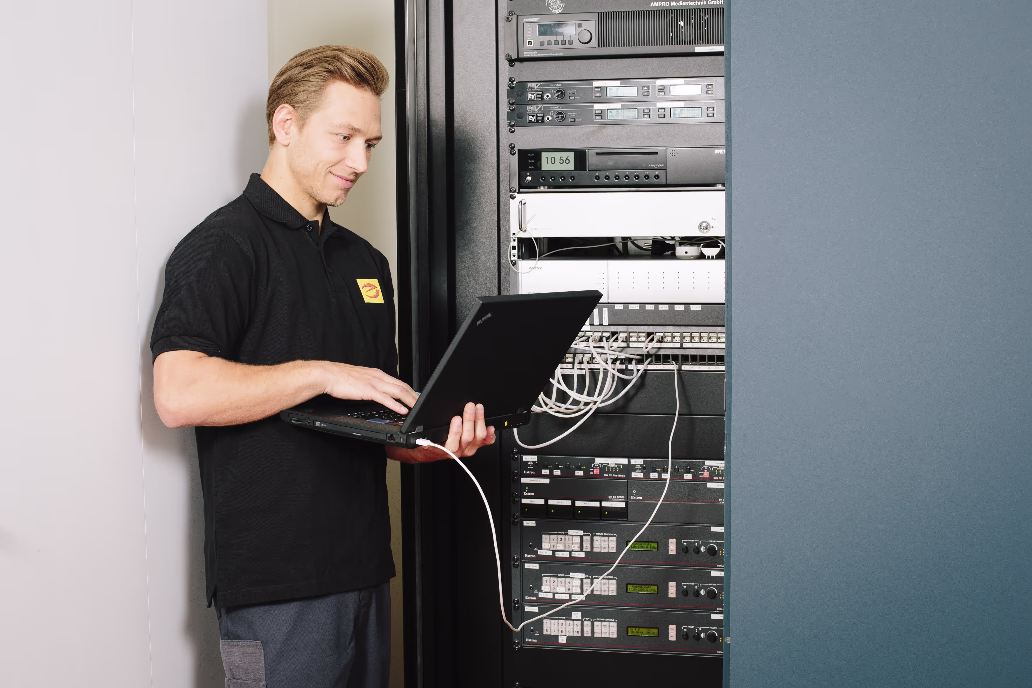 Netzwerktechnik und Datentechnik: Elektroniker mit Laptop vor Serverschrank.